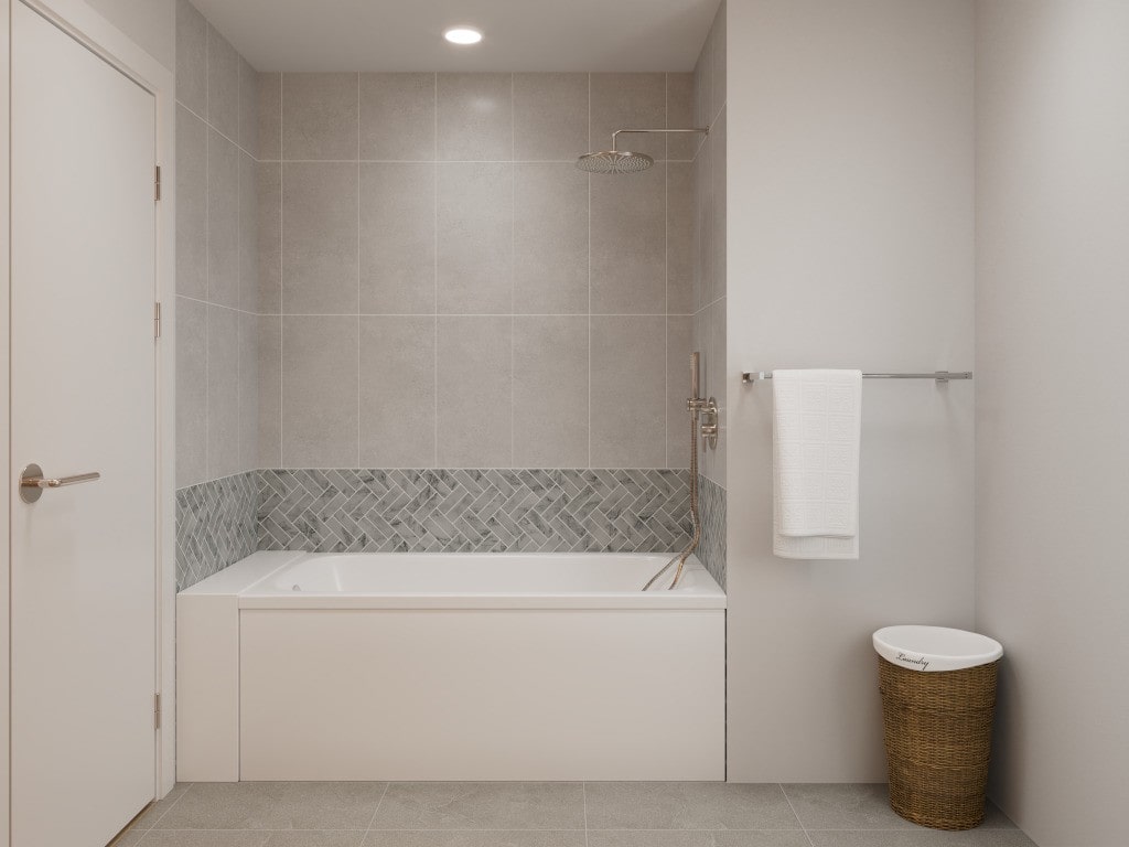A 3D rendering of a modern bathroom with a bathtub, gray large-format tiles, and a subtle herringbone mosaic accent, visualizing the finished design.