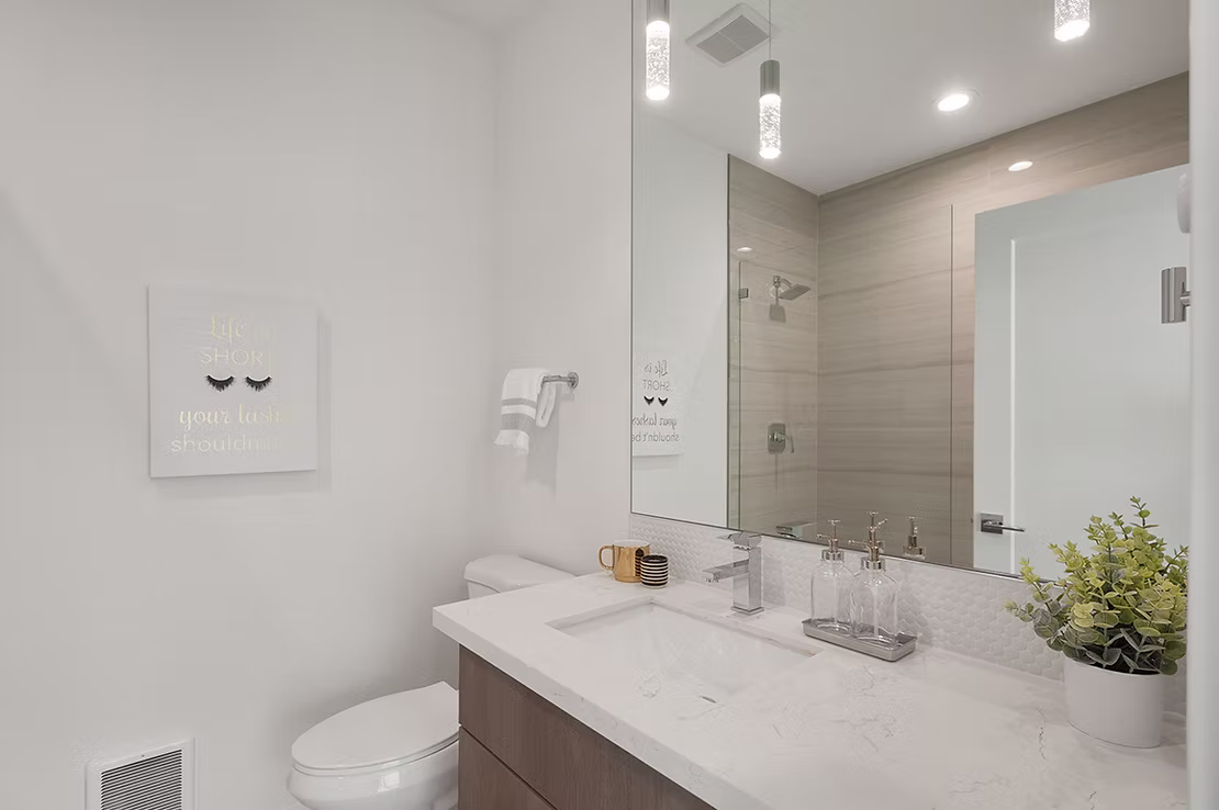 A modern bathroom with a floating vanity, a contemporary sink, and a mosaic tile backsplash, showcasing a unique and stylish finish from Oscar Surfaces.
