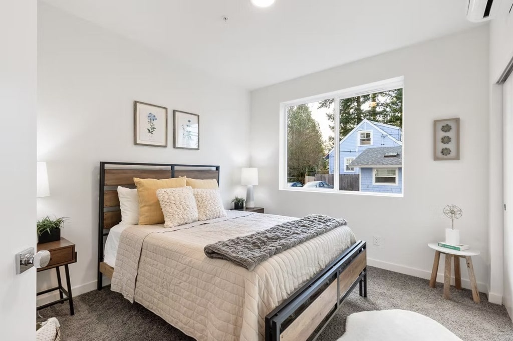 A fully furnished apartment bedroom with a modern wood and metal bed frame, showcasing the appealing interiors for potential renters.