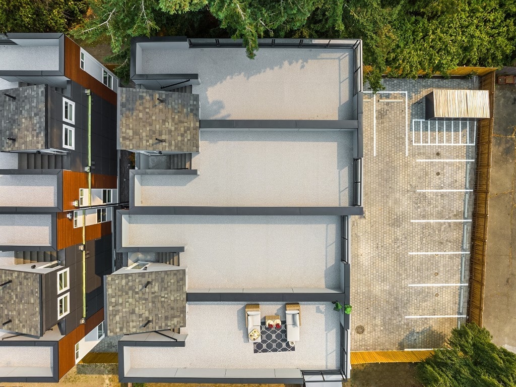An aerial view showing the multiple rooftop decks of a modern townhouse development, highlighting the outdoor living space and apartment complex layout.