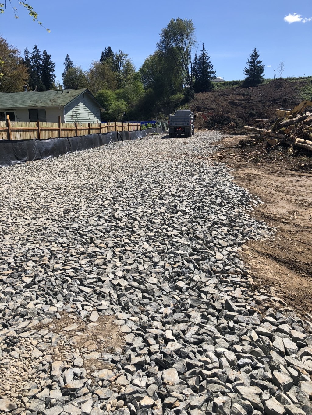 A newly graded construction site covered in large crushed rock, illustrating the base preparation phase of a development project.